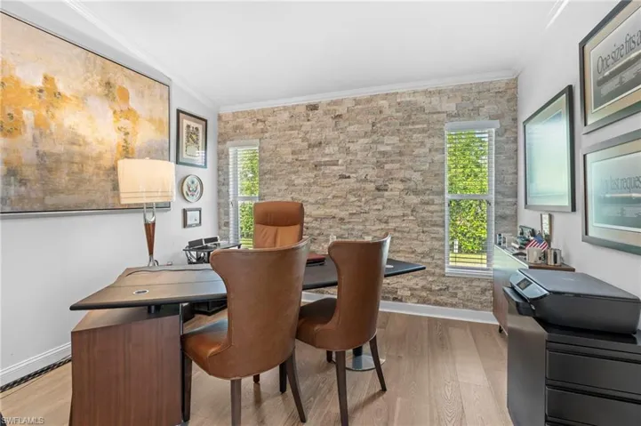 Dining area featuring ornamental molding, light wood finished floors, and an office area