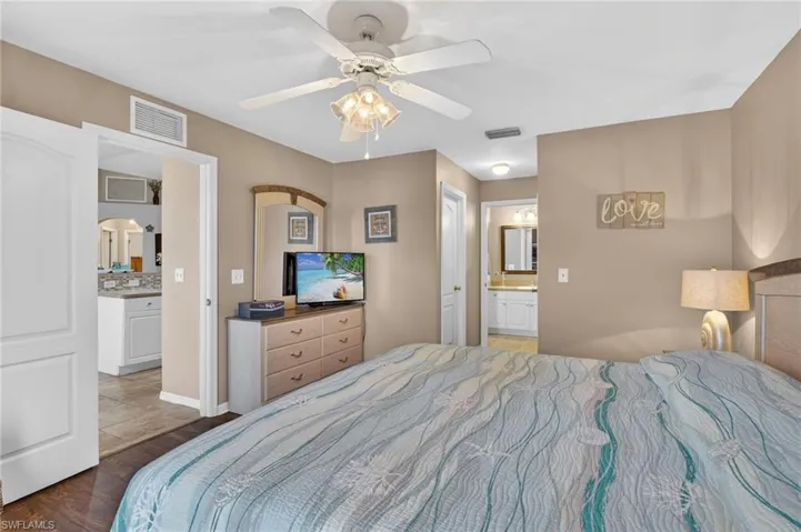 Primary bedroom with ensuite bathroom, ceiling fan, double walk-in closets