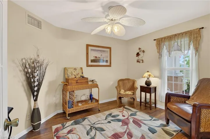 Flex space/den featuring dark wood-style floors and a ceiling fan