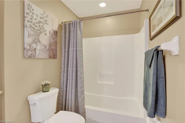 Full guest bathroom featuring shower / bath combo with recessed lighting