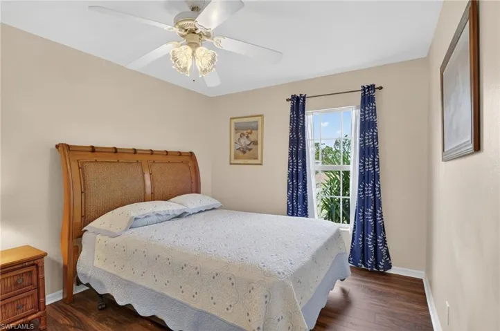 3rd bedroom featuring dark wood-look waterproof flooring, a ceiling fan, tall window & closet