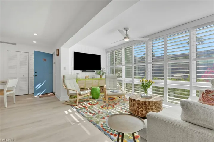 Living area featuring a ceiling fan, wood finished floors, expansive windows, and recessed lighting