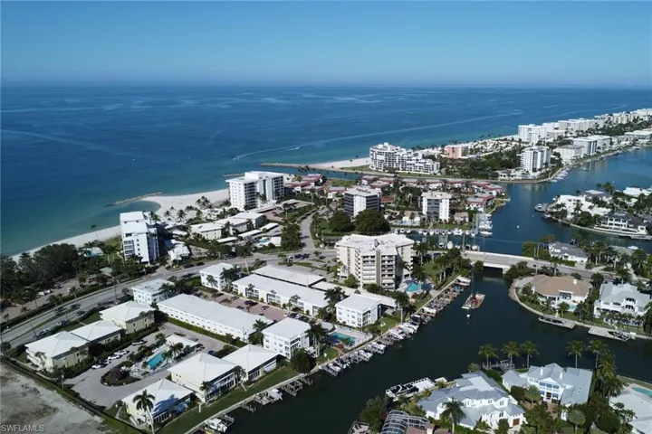 Aerial view of property and surrounding area with a large body of water and nearby urban area