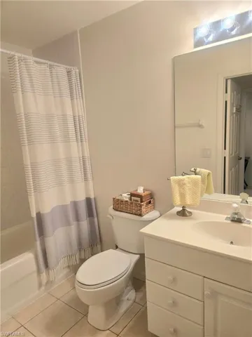 Bathroom featuring vanity, light tile  shower / bath combo