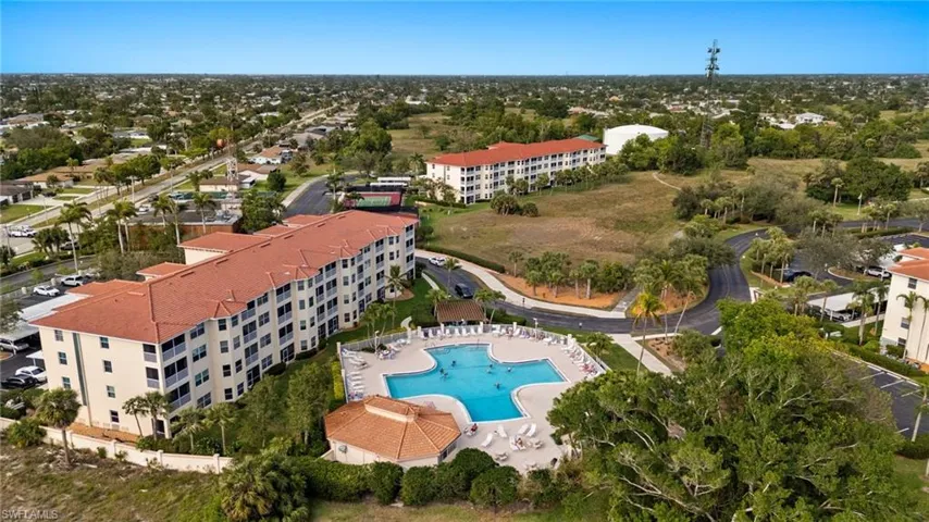 Drone / aerial view of apartment complex and a pool area