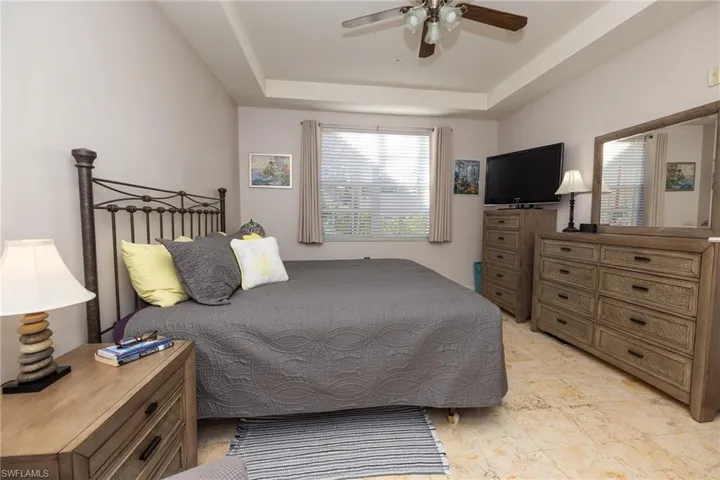 Bedroom featuring a tray ceiling and a ceiling fan