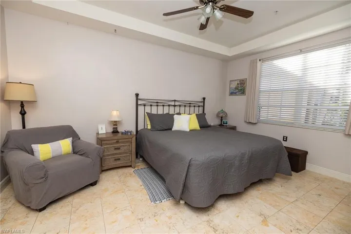 Bedroom with ceiling fan and a raised ceiling