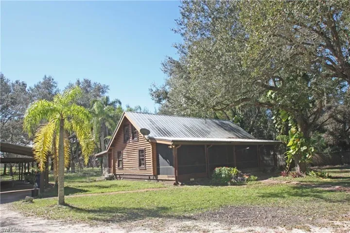 View of home's exterior with a sunroom and a lawn