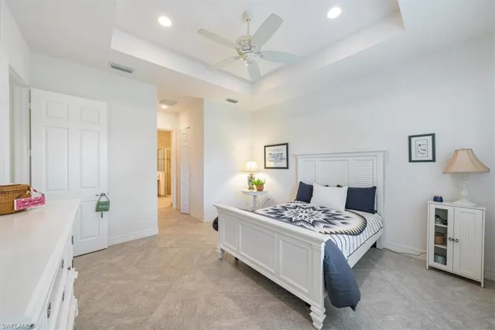 Bedroom featuring ceiling fan and a tray ceiling