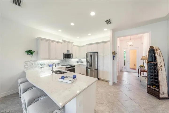 Kitchen with kitchen peninsula, stainless steel appliances, sink, and backsplash