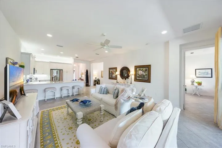 Living room with ceiling fan and light tile patterned flooring