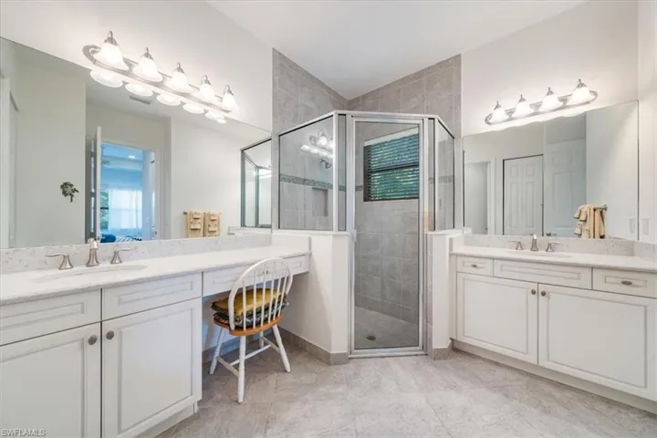 Bathroom featuring vanity, tile patterned floors, and a shower with door