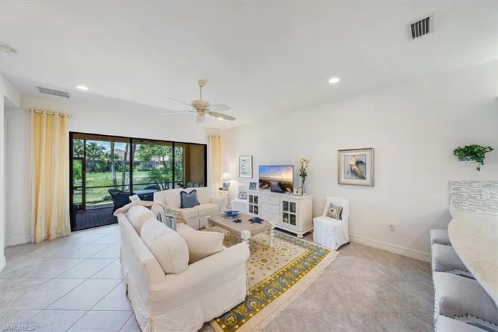 Living room with ceiling fan and light tile patterned floors