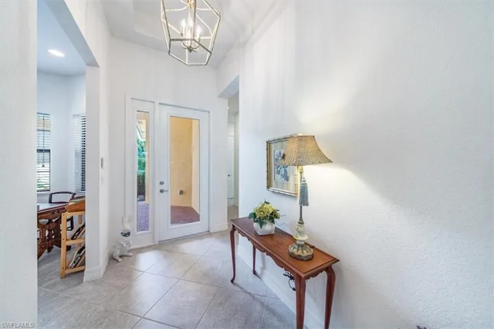 Tiled foyer entrance with an inviting chandelier