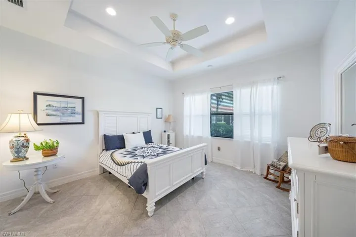 Bedroom with a tray ceiling and ceiling fan