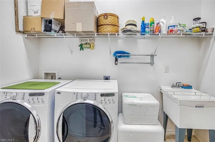 Laundry area featuring a textured wall and washing machine and clothes dryer