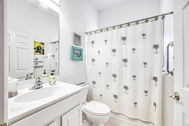 Full bathroom featuring curtained shower and vanity