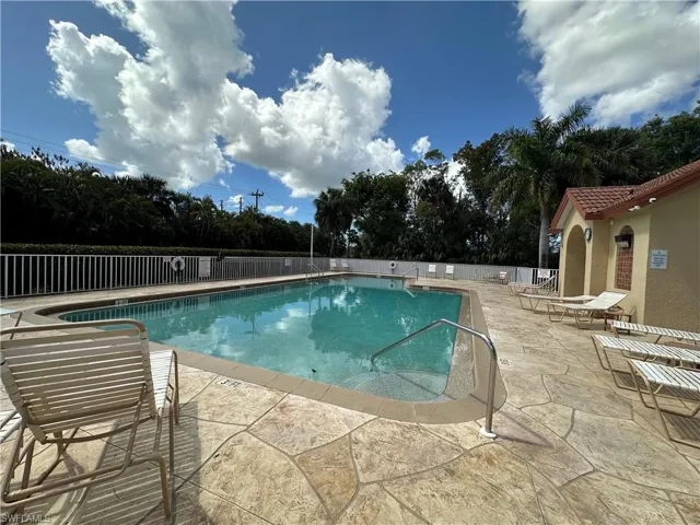 Community pool with a patio and view of scattered trees