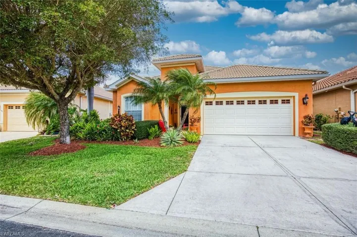 Mediterranean / spanish home with an attached garage, a front lawn, stucco siding, a tile roof, and driveway