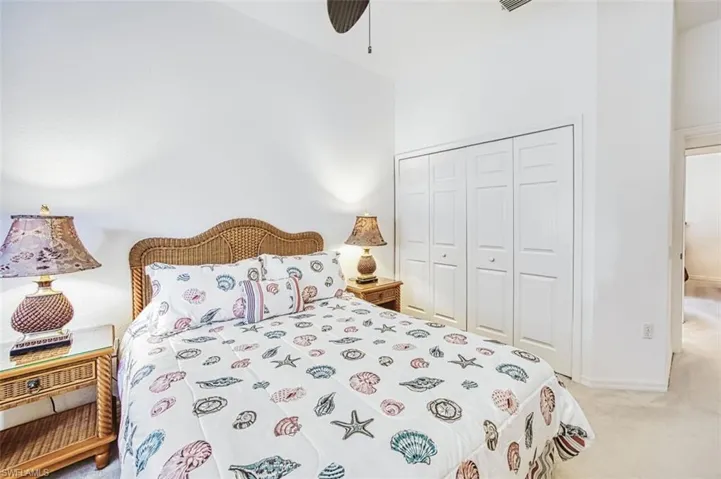 Bedroom featuring light colored carpet, a closet, and ceiling fan