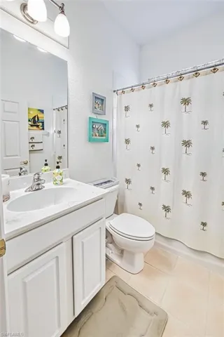 Bathroom with vanity, curtained shower, and light tile patterned floors