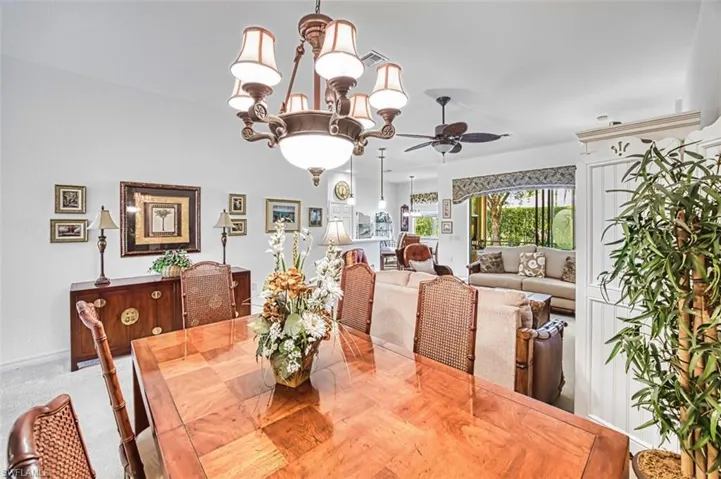 Carpeted dining area featuring hanging lights and a ceiling fan