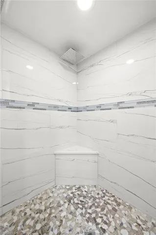Full bathroom with a marble finish shower