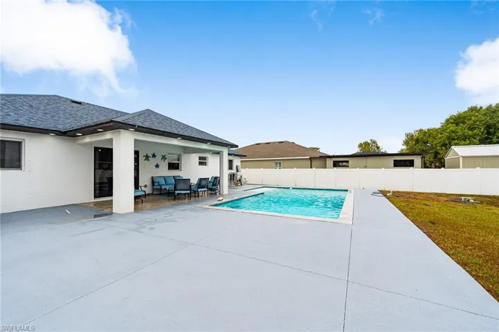 View of pool featuring patio surround, a fenced backyard, and an outdoor lounge area