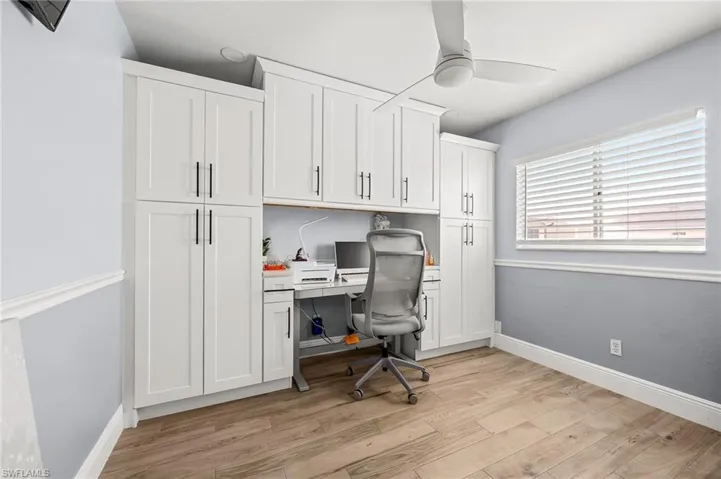 Office featuring ceiling fan, light wood finished floors, and built in desk
