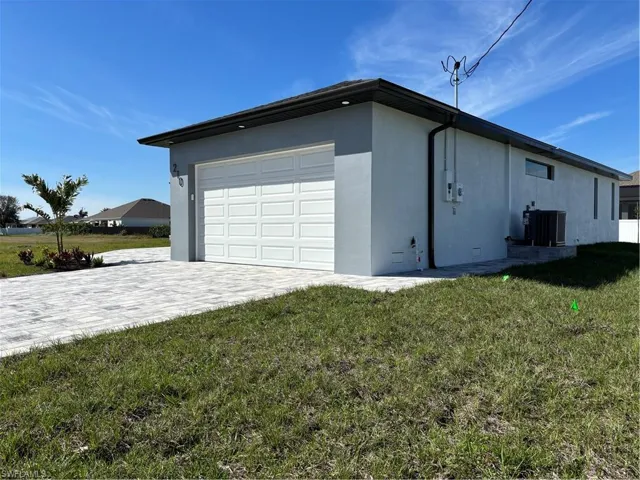 Garage featuring central AC and decorative driveway