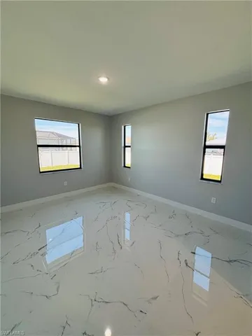 Spare room with porcelain finish floor, baseboards, and recessed lighting