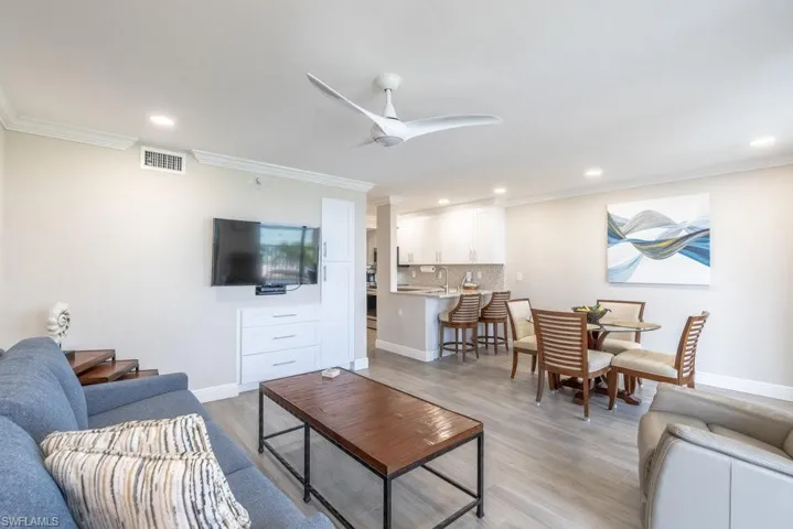 Living area featuring crown molding, light wood-style flooring, recessed lighting, and a ceiling fan