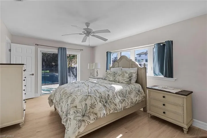 Bedroom featuring access to outside, light wood-type flooring, and a ceiling fan