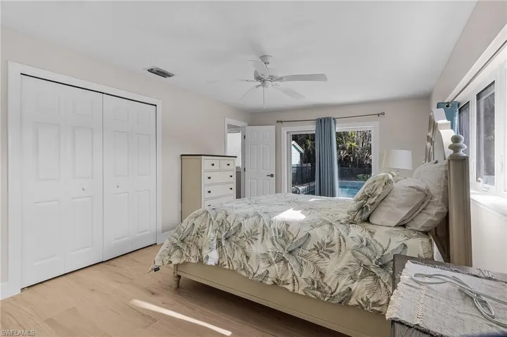 Bedroom with light wood-type flooring, a ceiling fan, and a closet