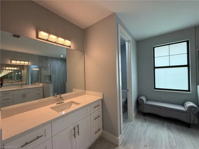 Bathroom featuring hardwood / wood-style flooring, vanity, and toilet