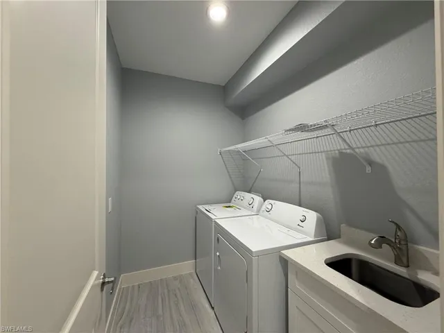 Laundry area featuring independent washer and dryer and sink