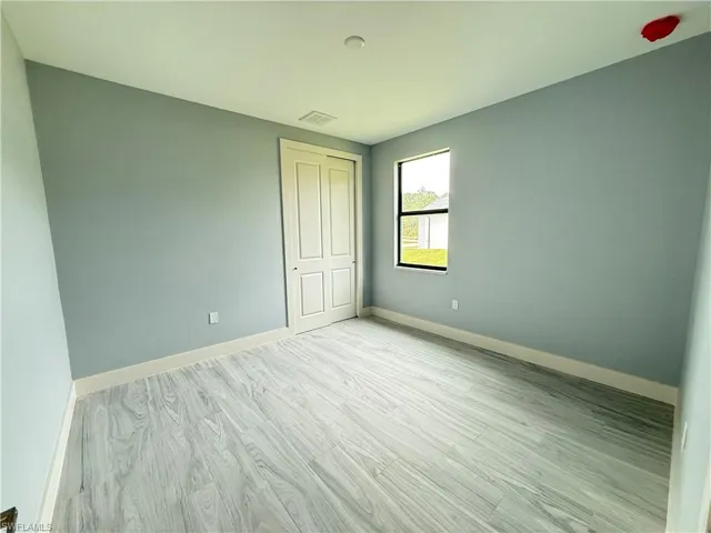 Unfurnished bedroom with light wood-type flooring and a closet