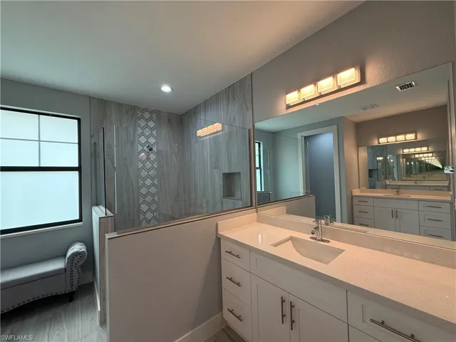 Bathroom featuring vanity and tiled shower