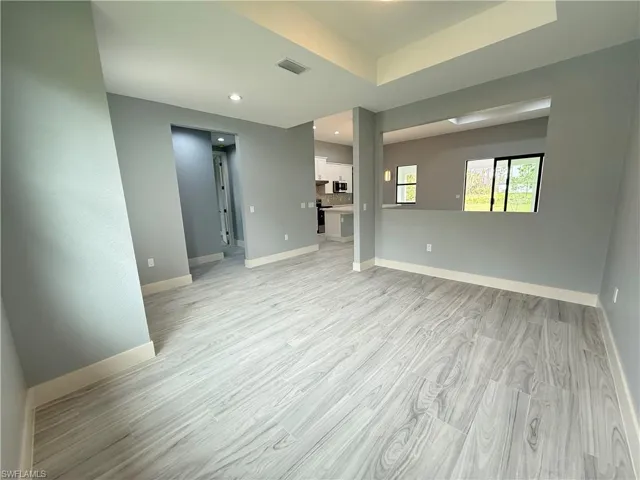 Spare room featuring a raised ceiling and light hardwood / wood-style flooring