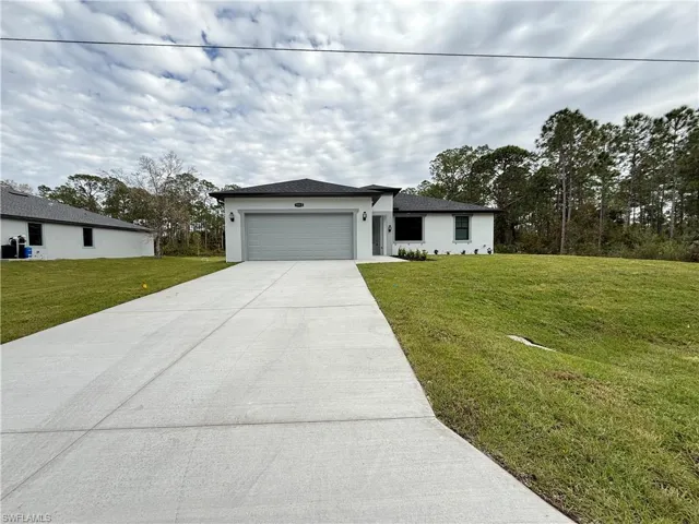 View of front of house with a front yard and a garage