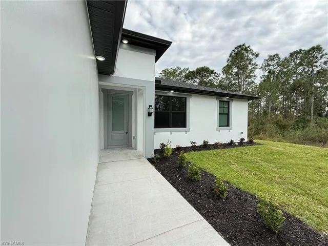 Entrance to property with a lawn