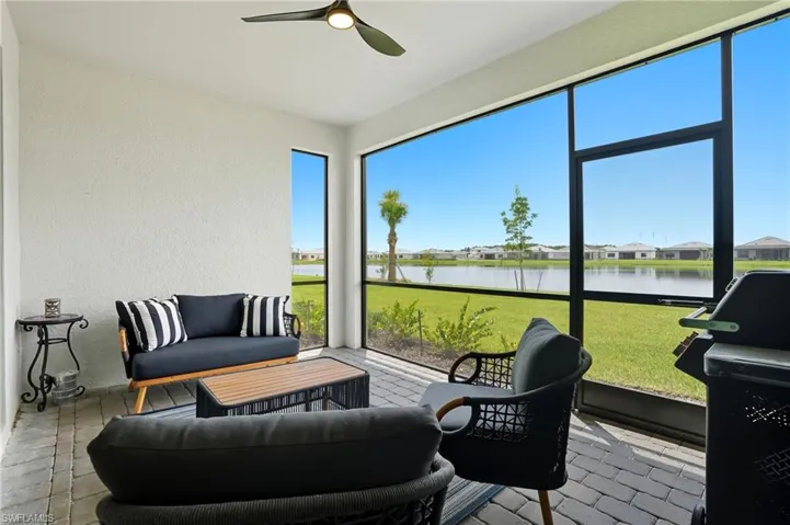 Sunroom / solarium featuring a ceiling fan, a water view, and a residential view