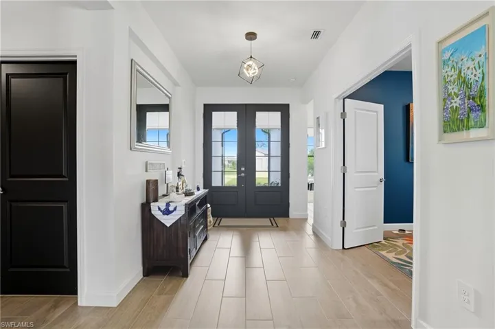 Foyer entrance featuring healthy amount of natural light, wood tiled floors, and french doors