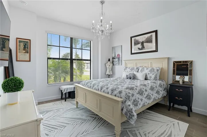 Bedroom featuring wood tiled floors and a chandelier