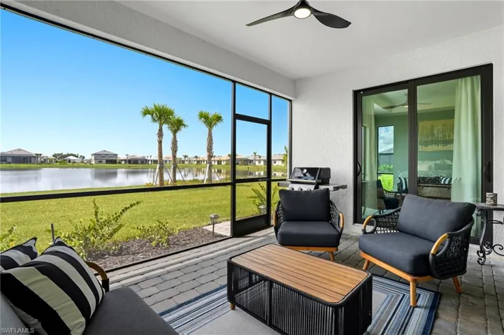 Sunroom featuring a water view, a residential view, ceiling fan, and an outdoor hangout area