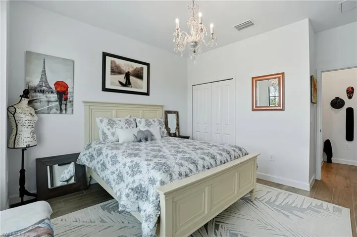 Bedroom with light wood-type flooring, a closet, and a chandelier