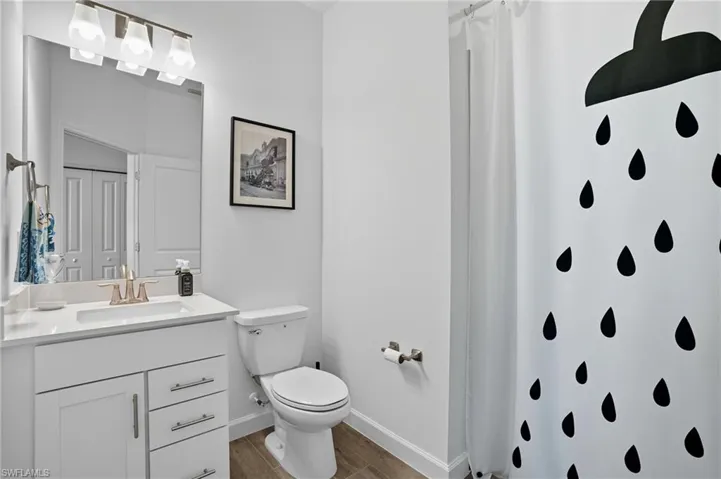 Bathroom with vanity, a shower with curtain, and light wood-style flooring