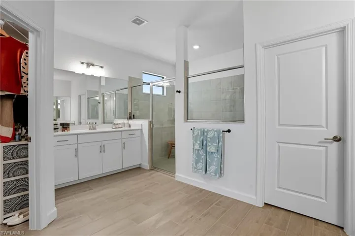 Bathroom with vanity, a stall shower, wood tiled floors, and recessed lighting