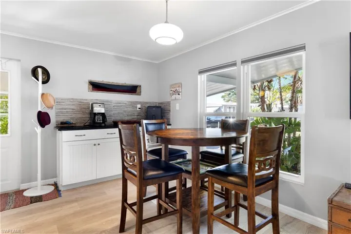 Dining space featuring crown molding, light wood-style floors, and healthy amount of natural light