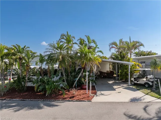 View of front of home with concrete driveway and a carport